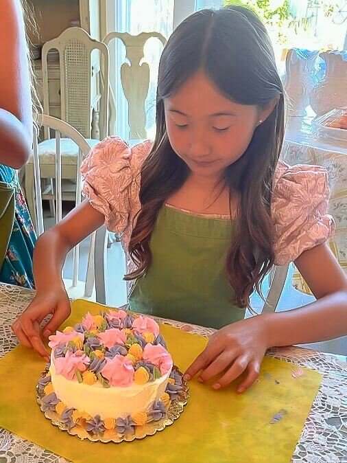 A girl admires her cake decoration.