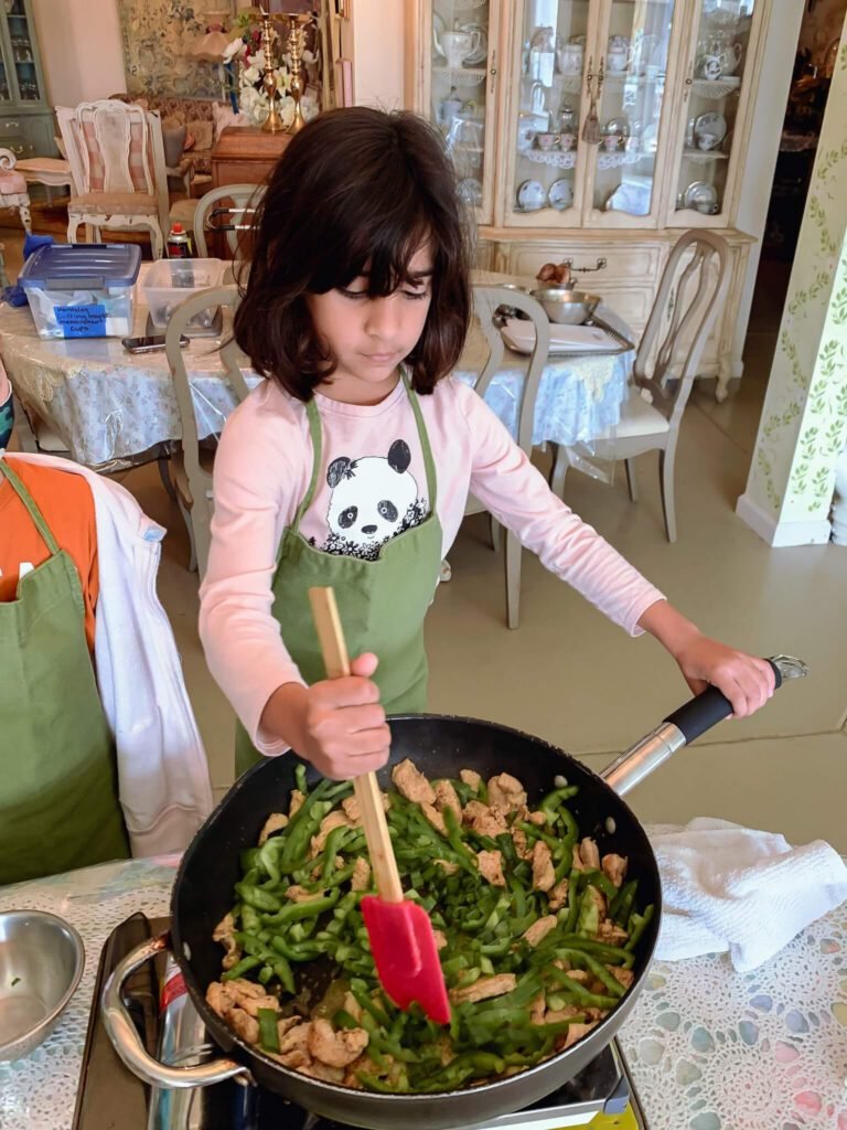A little girl cooks Mexican food.